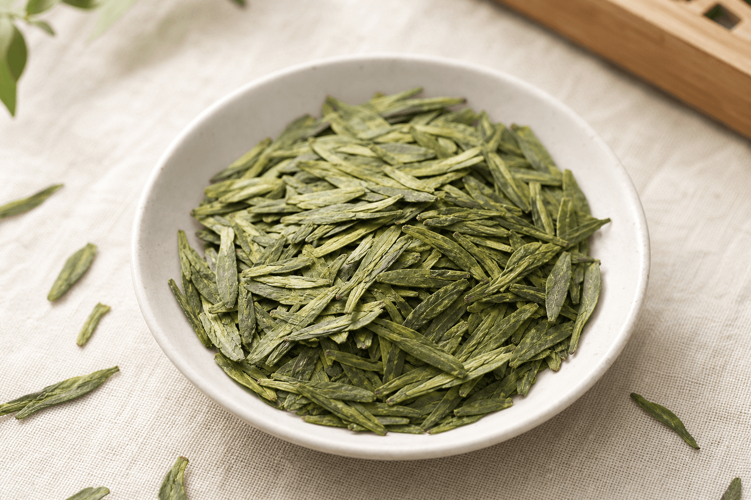 Close-up of flat lance-shaped jade-green dry Long Jing leaves in a shallow porcelain dish