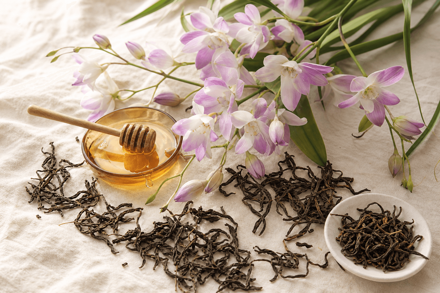 Orchid sprigs with honey and long twisted Mi Lan Xiang leaves on cream linen